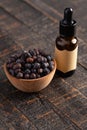 Juniper Berry Essential Oil on a Distressed Wooden Table Royalty Free Stock Photo