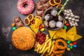 Junk food concept. Unhealthy food background. Fast food and sugar. Burger, sweets, chips, chocolate, donuts, soda, top view Royalty Free Stock Photo