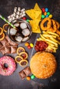 Junk food concept. Unhealthy food background. Fast food and sugar. Burger, sweets, chips, chocolate, donuts, soda, top view Royalty Free Stock Photo