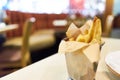 Junk food, French fries contained in stainless steel cup placed on a table. Restaurant scene and copy space.