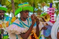 Junkanoo performers dressed in traditional costumes at a festival playing a trumpet in Freeport, Bahamas