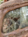 Junkyard abandoned rusty old car with broken window Royalty Free Stock Photo