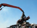 Junkyard crane with claw and crushed car Royalty Free Stock Photo