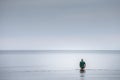 JURMALA, LATVIA - AUGUST 26, 2023: Selective blur on a middle aged man, bathing in the cold sea in Jurmala, trying to enter the