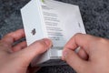 Jurmala, Latvia - 21 09 2023: Unboxing new Apple gadget. Woman tears off a protective strip in a box with new headphones