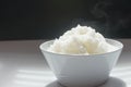 Jasmine steamed rice just finish cooked for breakfast time, in White bowl on white and black background.