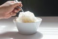 Jusmine steamed rice, in White bowl taking with spoon