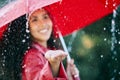 Just another lovely rainy day. Closeup shot of a young woman standing in the rain with an umbrella. Royalty Free Stock Photo