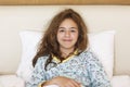 Just awake pretty teenager girl with funny emotion face and wild hair on the bed