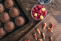 Just baked chocolate cupcakes in bakeware and seasonal fruits and berries. Flat lay. Top view Royalty Free Stock Photo