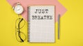 Just Breathe Notice on the notepad with pen, glasses and alarm clock Royalty Free Stock Photo