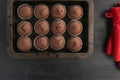 Just cooked homemade cupcake. Chocolate brownies muffins on baking sheet and red pot-holders on black background Royalty Free Stock Photo
