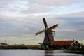 A sIngle dutch windmill with a traditional wooden house in a Netherland`s landscape. Royalty Free Stock Photo