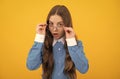 Just curious. Curious girl in eyeglasses. Nerdy-looking kid yellow background. Back to school