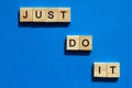 Just do it - the motivating inscription is laid out on a blue background with wooden blocks with black letters. Call to action