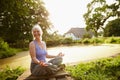 Just enjoying the beauty around her. Shot of an attractive mature woman meditating in a garden at sunset. Royalty Free Stock Photo