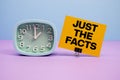 Just The Facts text and alarm clock on blue and purple background Royalty Free Stock Photo