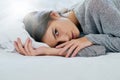 Just five more minutes. Portrait of an attractive young woman lying bed while smiling brightly at home during the day. Royalty Free Stock Photo