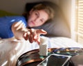 Just five more minutes. a young woman waking up and reaching for her alarm clock at home. Royalty Free Stock Photo