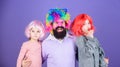 Just for fun. Party time. How crazy is your father. Man bearded father and kids girls wear colorful wig violet