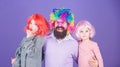 Just for fun. Party time. How crazy is your father. Man bearded father and kids girls wear colorful wig violet