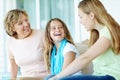 Just the girls. A cute young girl sitting inbetween her mother and grandmother smiling happily. Royalty Free Stock Photo