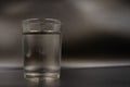 Just a glass of water on a dark wooden table. Mineral water in a glass on a black background. A glass with water Royalty Free Stock Photo