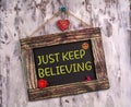 Just keep believing written on Vintage sign board Royalty Free Stock Photo