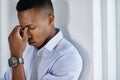 Just keep calm and carry on. a young and stressed businessman suffering from a headache while trying to work in the Royalty Free Stock Photo