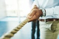 Just keep pulling once success is within your grasp. an unrecognisable businessman pulling on a rope during tug of war. Royalty Free Stock Photo