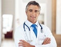 Just leave everything up to me. Cropped portrait of a handsome mature male doctor standing with his arms crossed in the Royalty Free Stock Photo