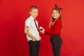Valentine`s day celebration, happy caucasian kids isolated on red background Royalty Free Stock Photo