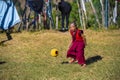 A young monk playing a broken football , Bhutan