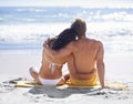 Just listening to the surf...A loving young couple embracing one another on the beach while looking to the horizon. Royalty Free Stock Photo