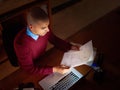 Just a little late night reading. High angle shot of a young man reading paperwork while working late in the office.