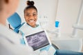 Just a little while longer. a dentist looking over a patients x-rays before a procedure. Royalty Free Stock Photo