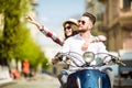 Just look at that. Beautiful young couple riding scooter together while happy woman pointing away and smiling Royalty Free Stock Photo