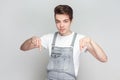 Just look down. Self confident serious young brunette man standing points down, advertises something Royalty Free Stock Photo