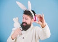Just look at that egg. Bearded man with bunny toy and Easter egg. Easter bunny delivering colored eggs. Celebration of Royalty Free Stock Photo