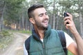 Just look! I am here! Handsome young man carrying backpack and taking a picture of himself and pointing to the gorgeous view Royalty Free Stock Photo