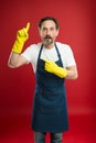 Just look over there. Mature man pointing finger up in yellow gloves. Mature household worker presenting something Royalty Free Stock Photo