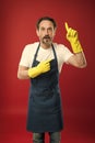 Just look over there. Mature man pointing finger up in yellow gloves. Mature household worker presenting something Royalty Free Stock Photo