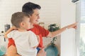 just look over there - young father looking out of the window with his little son, medium closeup Royalty Free Stock Photo