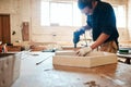 Just making some final adjustments to the masterpiece. A handsome young carpenter using an electric drill while working