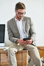 Just making a to-do list. a casually-dressed young man using a digital tablet at his desk.