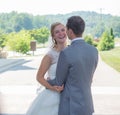 Just-married couple hugging each other and laughing in a park surrounded by hills and greenery Royalty Free Stock Photo