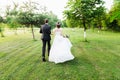 Just married couple running away in a green summer garden Royalty Free Stock Photo