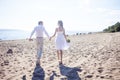 Just married happy couple running on a sandy beach Royalty Free Stock Photo