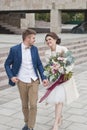 Just married loving couple in wedding dress and suit . Happy bride and groom walking running in the summer city. Royalty Free Stock Photo