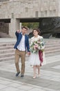 Just married loving couple in wedding dress and suit . Happy bride and groom walking running in the summer city. Royalty Free Stock Photo